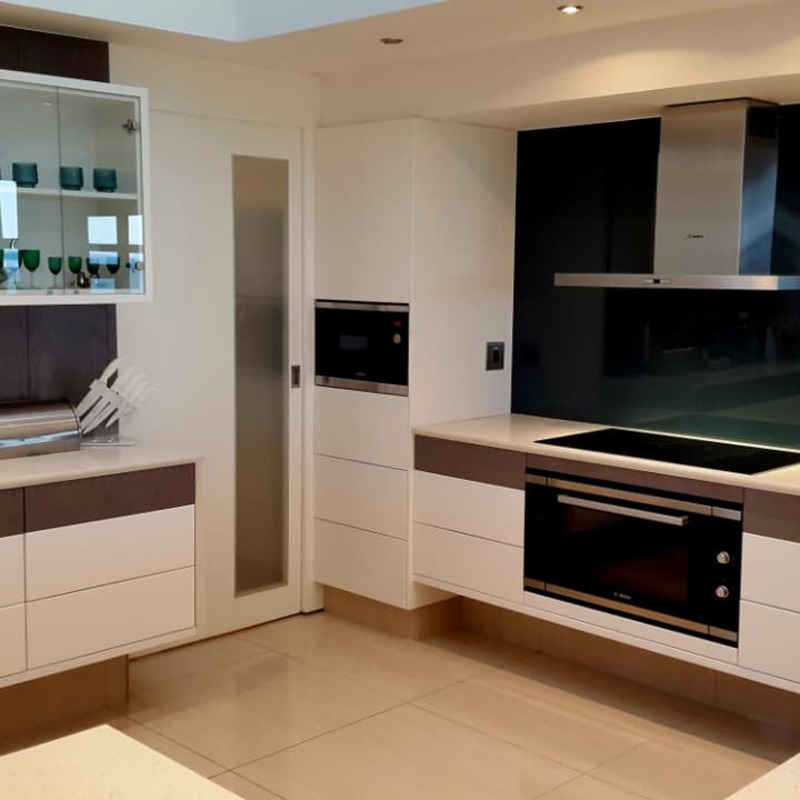Kitchen with built-in oven and dark splashback